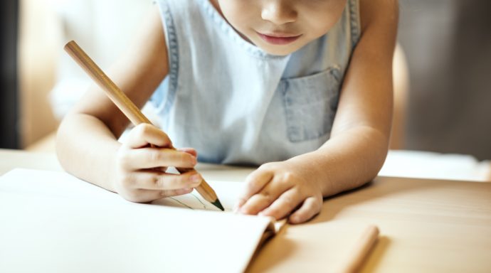 Young homeschool student writing with a pencil